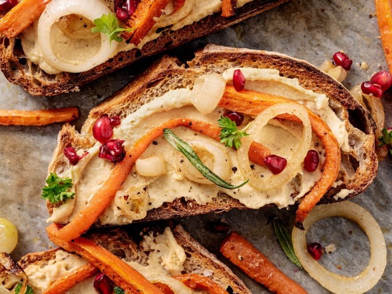 Toast met hummus, harissa wortels & granaatappel