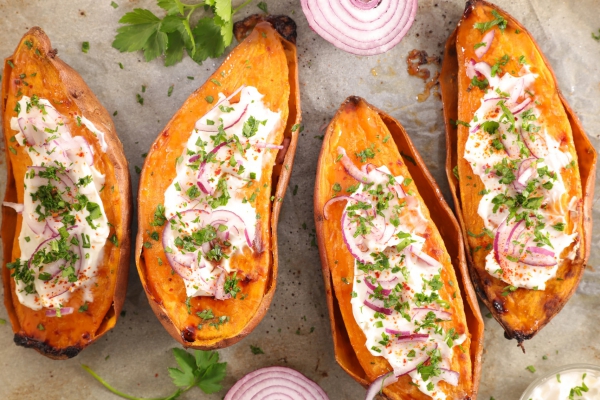 In de oven gepofte zoete bataat met room en verse kruiden