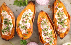 In de oven gepofte zoete bataat met room en verse kruiden