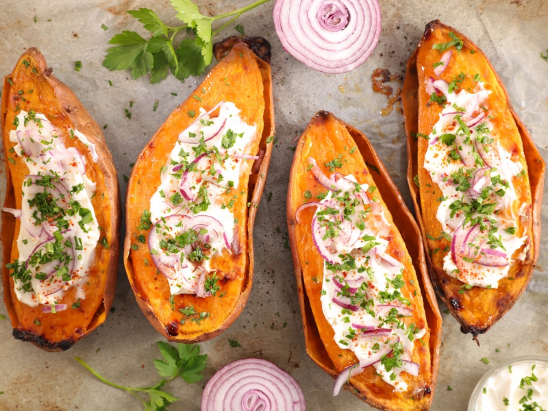 In de oven gepofte zoete bataat met room en verse kruiden